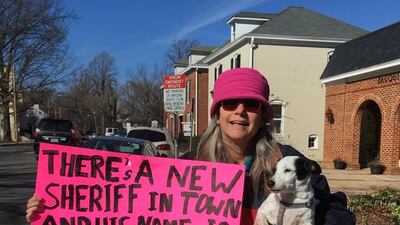 Kelly Anne Finn and her dog Jack in Warrenton, Virginia, with a sign she made in support of US president Donald Trump. Thomas Seibert for The National
