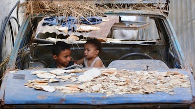 Palestinian children sit in the wreckage of a car in the Bureij refugee camp in the central Gaza Strip. AFP