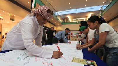 UAE residents and visitors at Abu Dhabi Mall play their part in Longevity to UAE’s record attempt. Ravindranath K / The National