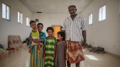 Ibrahim Omar, 45, right, and his children, Aseya, 3, Heyam, 6, Maryam, 10, and 1-year-old Saeed, pose for a photo in their room, at an orphanage that has been turned into a center for Yemeni refugees.