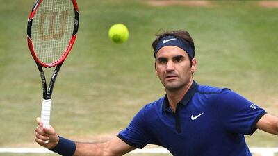 Roger Federer from Switzerland returns a ball to Dominic Thiem from Austria during the semifinal match of the MercedesCup ATP tennis tournament in Stuttgart, Germany, Saturday June 11, 2016. (Marijan Murat/dpa via AP)