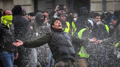 Protesters in an anti-government demonstration are showered by a police water hose. Loic Venance / AFP