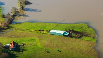 An arial photo of a farmhouse surrounded by floodwaters from an extreme high tide along the Coquille River in southwest Oregon taken as part of the Oregon King Tides Project. Rena Olson via AP