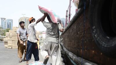 A group of sailors in Dubai loading bags of rice onto their boat. Lee Hoagland/The National
