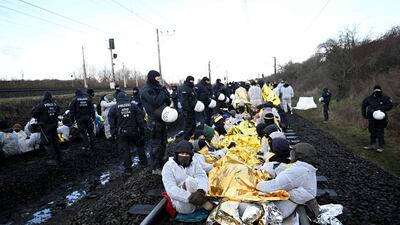 Police stand next to environmentalists blocking railway tracks used to transport lignite to energy supplier RWE's coal-fired power plant in Neurath, western Germany. AFP
