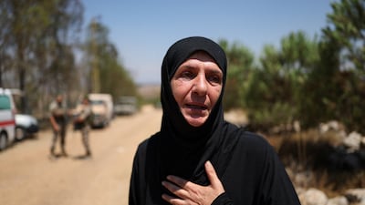 A resident waits at the entrance to her village. Reuters
