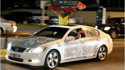 Football fans celebrate at the intersection of Khaleej al Arabi Street and the Corniche after the UAE President's Cup, Monday, April 11, 2011 in Abu Dhabi.
