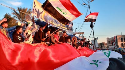 Anti-government protesters chant slogans while holding national flags during a demonstration against the newly appointed Prime Minister designate Mohammed Allawi, Monday, Feb. 3, 2020, in Tahrir Square, Baghdad, Iraq. AP