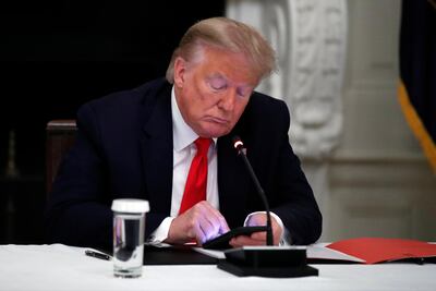 President Donald Trump looks at his phone during a roundtable with governors in the White House in Washington, June 18, 2020. AP