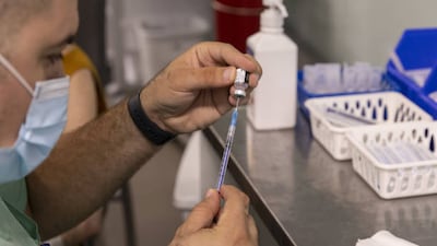 A health worker in Israel prepares a booster dose of the Pfizer-BioNTech Covid-19 vaccine. BioNTech has raised its forecast for this year’s Covid-19 vaccine sales to $18.7 billion. Bloomberg via Getty Images