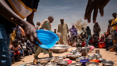 Sudanese refugees receive food at an Emergency Response Room Communal Kitchen while being relocated to the Iridimi transit camp near the Sudan-Chad border in Tine. Getty Images