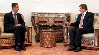 TURKISH FOREIGN MINISTRY / HAKAN GOKTEPE" - NO MARKETING NO ADVERTISING CAMPAIGNS - DISTRIBUTED AS A SERVICE TO CLIENTS A handout picture from the Turkish Foreign Minister shows Syrian President Bashar Al Assad, left, met with Turkish Foreign Minister Ahmet Davutoglu in Damascus on Tuesday.