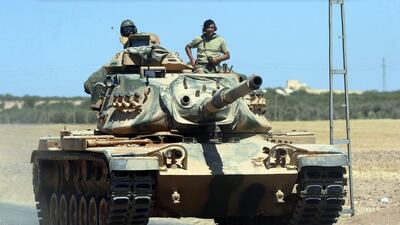 A Turkish tank heads towards the Syrian border, in Karkamis. Ismail Coskun / IHA via AP