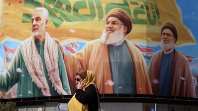 An Iranian woman walks past a billboard in Tehran on Saturday. Embargoes, asset freezes and other punitive measures threaten to damage Iran’s already fragile economy. EPA