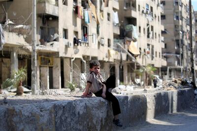 A child sits in a street during a media tour in Douma near Damascus, Syria on April 23, 2018. Ali Hashisho / Reuters