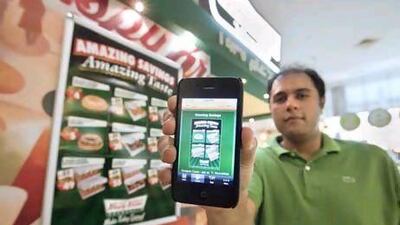 UAE - Dubai - March 02- 2011: Mihir Shan show his iphone with the ishopaholic application for Krispy Kreme at Ibn Batuta Mall. ( Jaime Puebla - The National Newspaper )