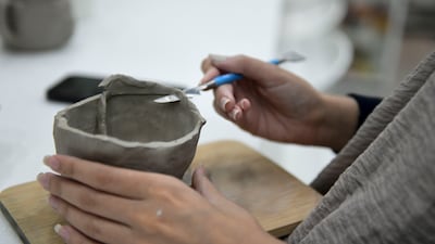 A student uses a sculpting tool.
