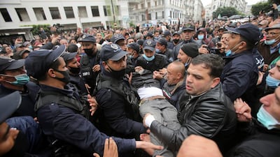 A man is carried by police and protesters during a rally marking two years since the start of a mass protest movement demanding political change, in the Algerian capital, Algiers. Reuters