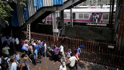 Commuters stand under a pedestrian bridge where a stampede took place at the Elphinstone local station, in Mumbai. Rafiq Maqbool / AP Photo