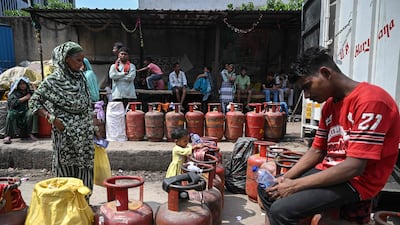 People queue to refill LPG cylinders, amid shortages in Noida. The energy crisis has forced India to crack down on hoarding of essential cooking commodities. AFP