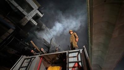 A fire official stands on a fire brigade truck. AP