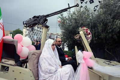 An Iranian bride and groom arrive in a military vehicle during a mass wedding ceremony organised under the 'Jan-Fada' (Sacrificing Life) campaign in Tehran. EPA