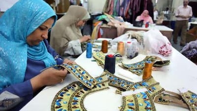 Zizi Mustafa, left, sews jewels and beads on to a collar in the Cairo Opera House's sewing room. The costume makers work around the clock to provide clothing for the ballet and opera productions.