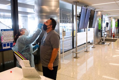 A traveller receives an in-airport Covid-19 nasal swab test a day before his flight to Hawaii at Los Angeles International Airport. Patrick Fallon / AFP