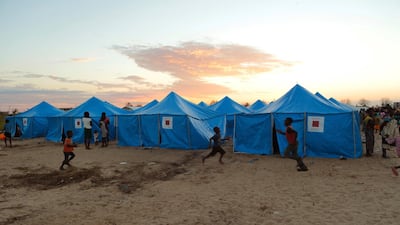 Women and children are outside a displacement camp in Beira, Mozambique, Sunday, March, 31, 2019. AP
