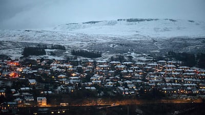 Snow-covered homes are illuminated at dusk in the village of Marsden, near Manchester. AFP