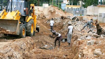 Indian labourers work on a road widening project in Bangalore, linking the city to the international airport. Dibyangshu Sarkar / AFP