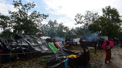 Rohingya refugees gather by newly built shelters at Kutupalong refugee camp in Bangladesh's Ukhiya district on September 9, 2017. Nearly 300,000 Rohingya Muslims have fled Myanmar's Rakhine state into Bangladesh in the 15 days since new violence erupted, the United Nations said on September 9. The figure has jumped about 20,000 in a day. Munir Uz Zaman / AFP