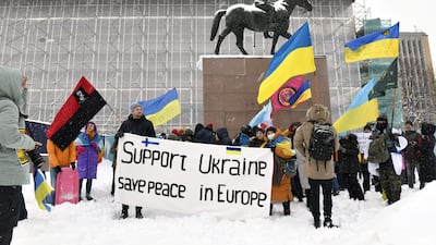 Protesters wave Ukrainian flags during a 'Support Ukraine' demonstration in central Helsinki as clouds of war gather. AFP