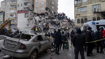 Emergency personnel search for victims at the site of a collapsed building in Diyarbakir, south-east Turkey, on Monday. EPA