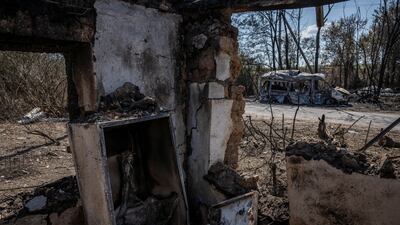 A destroyed car is seen from a destroyed building