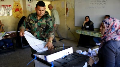 An Iraqi security member votes at a polling station in Baghdad. Thaier Al Sudani / Reuters