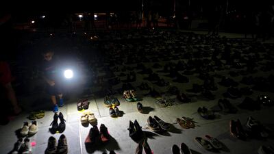 A child illuminates hundreds of shoes at a memorial for those killed by Hurricane Maria, in front of the Puerto Rico Capitol, in San Juan. Puerto Rico's Institute of Statistics announced that it has sued the US territory's health department and demographic registry seeking to obtain data on the number of deaths following Hurricane Maria as a growing number of critics accuse the government of lacking transparency. Ramon Espinosa / AP Photo