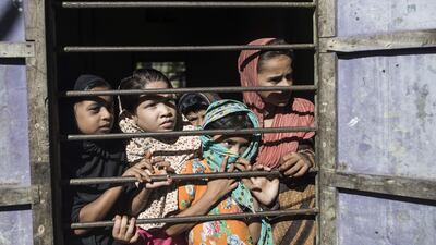 Bangladeshi girls look at the bodies of Rohingya Muslim refugees on Shah Porir Dwip Island near Teknaf on October 9, 2017, after a boat capsizing accident. Fred Dufour / AFP