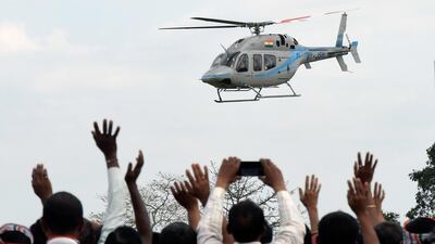 Supporters wave to Congress President Rahul Gandhi's helicopter as he arrives to address an election rally in Bokakhat, Golaghat district of Assam. EPA