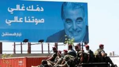 Members of a special commando unit of the Lebanese army pass in front of a poster of the slain former prime minister Rafik Hariri.