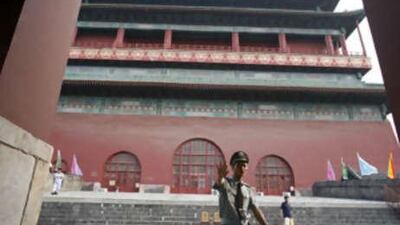 A security official stops people from entering the Drum Tower, a popular tourist spot, in central Beijing.