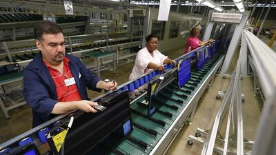 Workers use remote controls to check 32-inch television sets before they are repackaged at Element Electronics in Winnsboro, South Carolina. Element's plant in South Carolina has six assembly lines making 32- and 40-inch TVs that are now available in all of Walmart’s more than 4,000 US stores. Chris Keane / Reuters