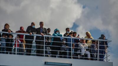 Migrants stand on a deck of a ship bound for Piraeus at the port of Mytilene, on the northeastern Aegean island of Lesbos, Greece, on Sunday, May 3, 2020. AP