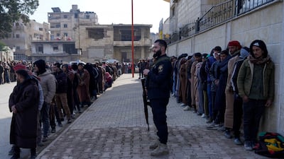 Members of the Kurdish-led SDF queue to settle their status with the Syrian government in Raqqa, Syria. Reuters