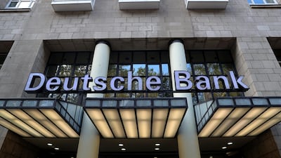 A sign sits above the entrance of a Deutsche Bank AG bank branch in Duesseldorf, Germany. Deutsche Bank's restructuring plan could be hampered by a weaker German economy. Bloomberg