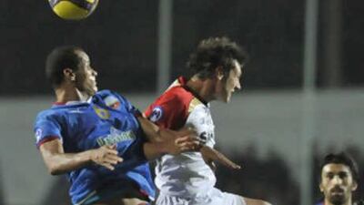 Bunyodkor's Rivaldo, left, jumps for the ball with Adelaide's Fabian Barbiero.