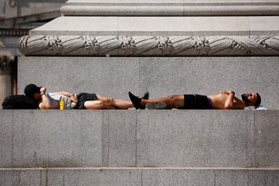 Two men sleep at the base of Nelson's Column in Trafalgar Square during hot weather in London on Thursday. AP