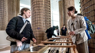 Visitors at the UAE pavilion ask about the traditional wooden loom, one of the interactive exhibits on display. Victor Besa / The National