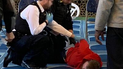 An image of a man being held down by police officers at a London mosque. Murshid Habib / Twitter