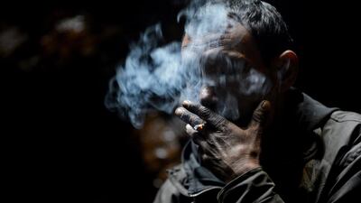A coal miner smokes a cigarette while taking a break near Rimbay village in the Indian state of Meghalaya. Roberto Schmidt / AFP Photo